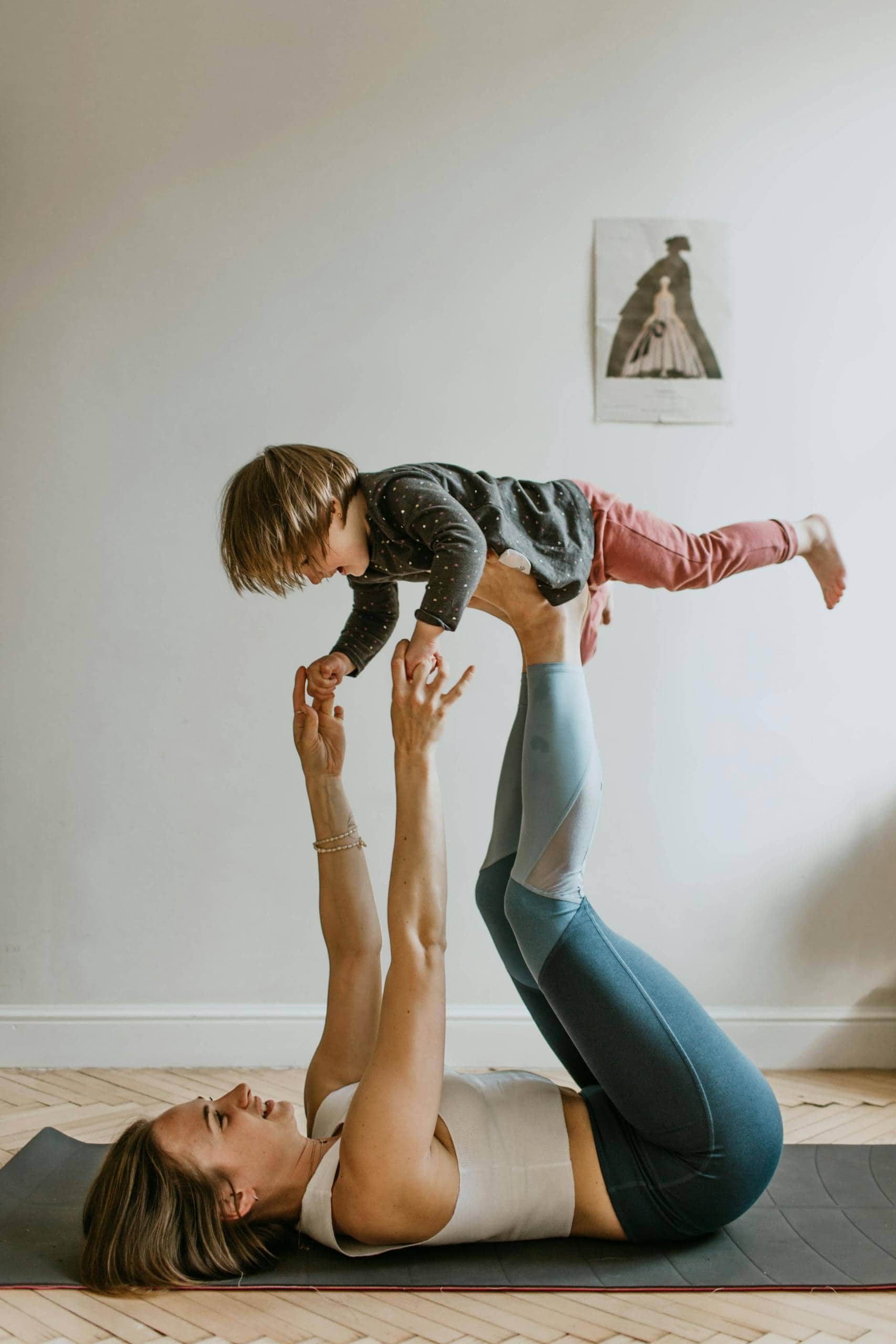 A mother and daughter bonding through acro yoga at home, showcasing strength, balance, and togetherness.