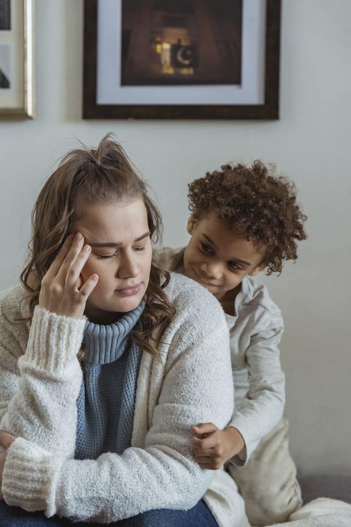 Mother and child at home, sharing a comforting and tender moment in the living room.