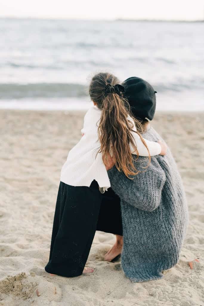 A touching moment of a mother and child hugging seaside, capturing love and togetherness.