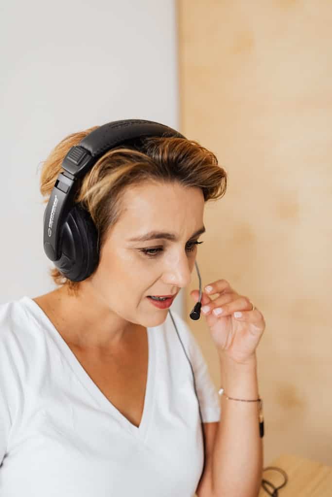 Focused woman with headset providing customer service assistance.