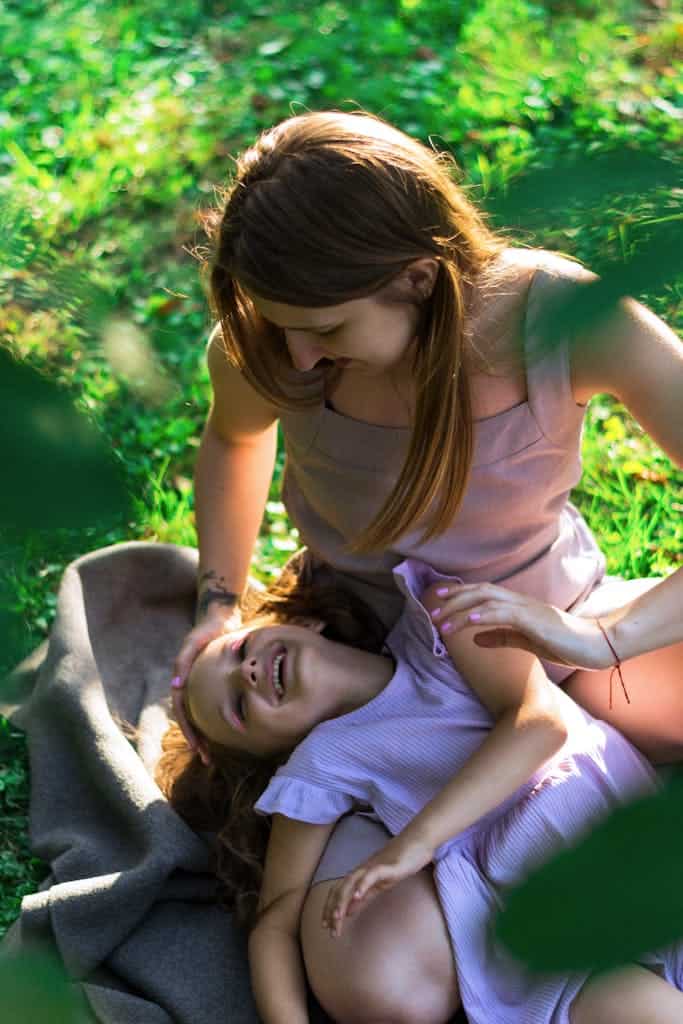 Joyful moment of a mother and daughter enjoying time in the sunlit garden.